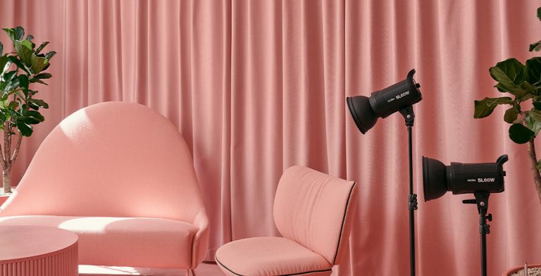 Vaaleanpunainen äänitys- ja podcast huone, jossa on Fabrican vaaleanpunaiset verhot, sohva, tuoli ja pöytä.