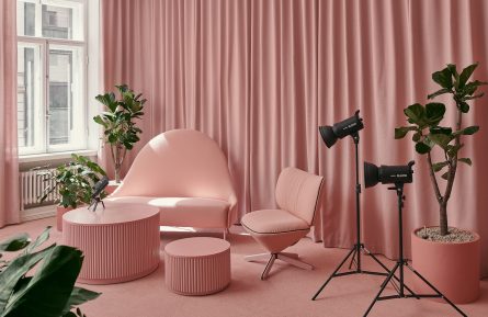 Vaaleanpunainen kuvaus- ja podcasthuone, jossa on Fabrican akustoivat tilanjakoverhot, tuoleja ja pöytä