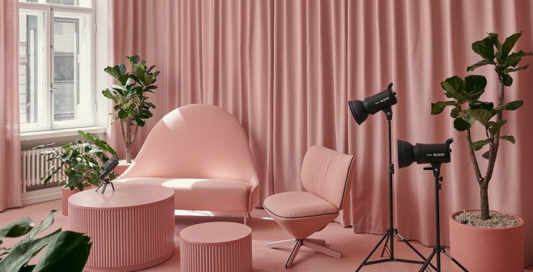 Vaaleanpunainen kuvaus- ja podcasthuone, jossa on Fabrican akustoivat tilanjakoverhot, tuoleja ja pöytä
